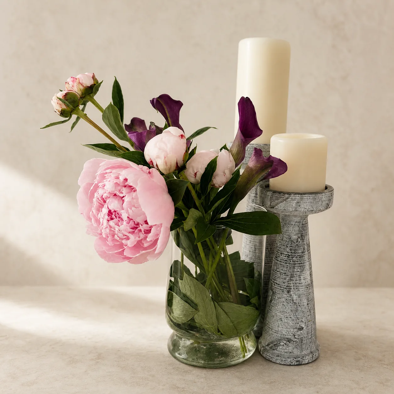 Peony and calla arrangement with candles