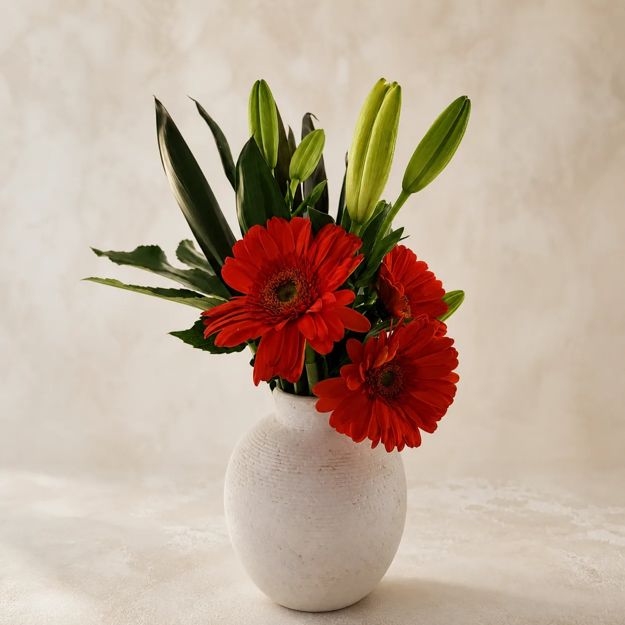 Red gerbera arrangement in an ivory vase