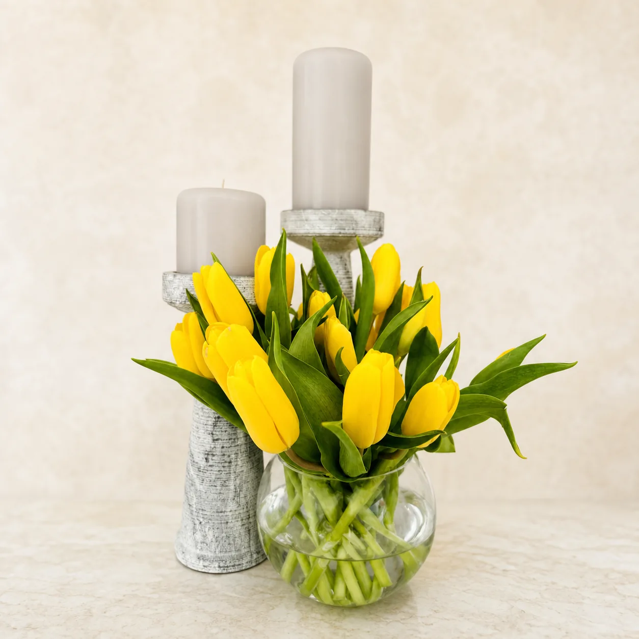 Yellow tulips arranged with ivory candles